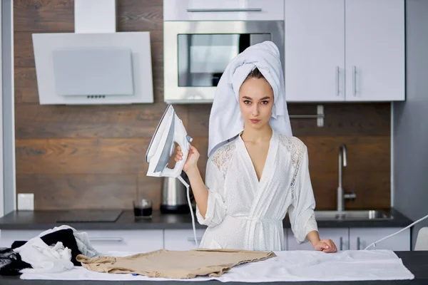 Portrait of cool woman with iron in hands — Stock Photo, Image