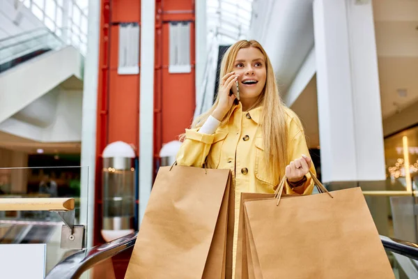 Pretty smiling woman in aisle of shopping mall — Stock Photo, Image