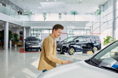 Mutlu genç adam tüm unsurları kontrol ediyor ve arabanın idealliğine bakıyor.