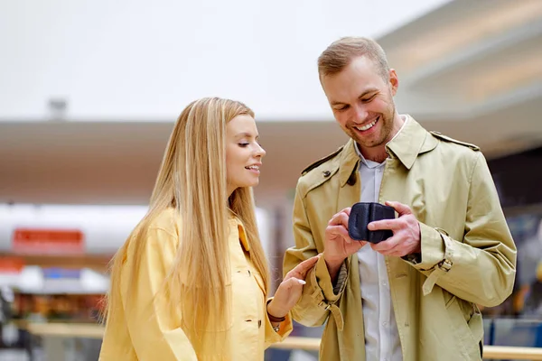 Glimlachende man en blonde vrouw kijk naar zijn portemonnee — Stockfoto