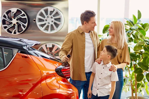 Talvez esta jovem família esteja a considerar comprar um carro novo. — Fotografia de Stock