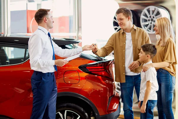 Bedårande familj få nycklar med bil i återförsäljare — Stockfoto
