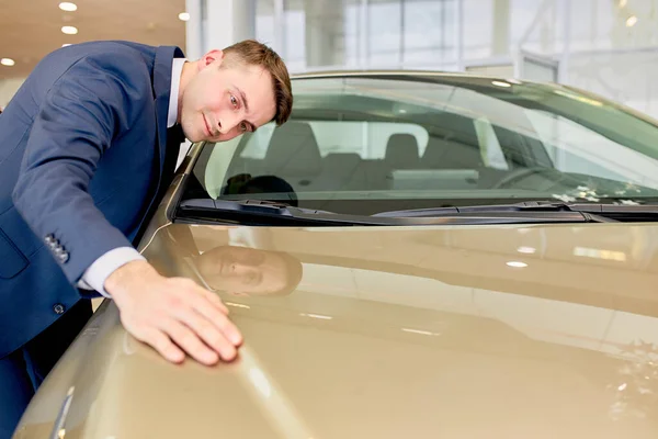 Jovem masculino toca representante automóvel em carros showroom — Fotografia de Stock