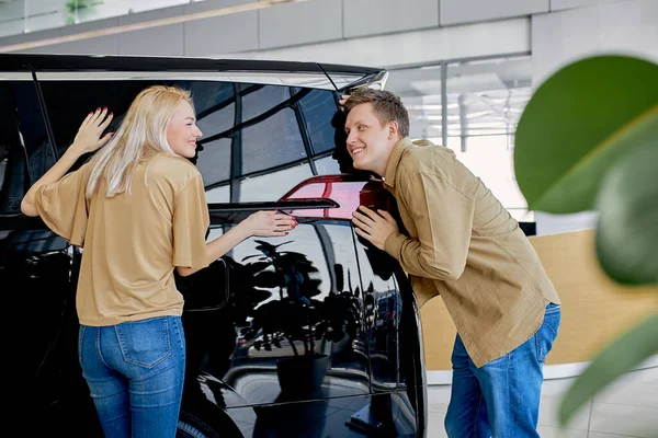 Glada ägare av ny bil i återförsäljaravtal — Stockfoto