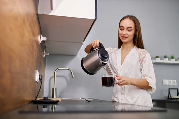 매력적 인 여인 이 커피를 잔에 붓는다 — 스톡 사진
