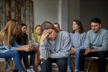 Toplumdan dışlanmış insanlar gruptan ayrı otururlar.