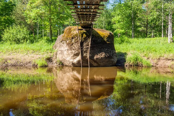 Letonya kırsalında küçük bir nehrin yanındaki büyük kaya parçası 