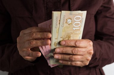 Kanada 'dan gelen para Kanada Doları. Öne bakan kişi fatura tutar.