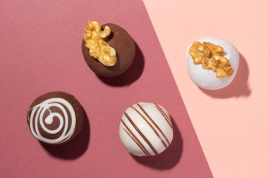 Çeşitli ev yapımı çikolatalı mantarlar. Lezzetli tatlı cazibe. Renk arkaplanındaki şeker toplarının düz tasarımı.