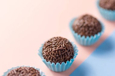 Brigadeiro, Brezilya 'dan tipik bir ev yapımı çikolatalı mantar. Kakao, konsantre süt ve çikolata parçacıkları. Çocukların doğum günü partisinde yaygındır. Şeker topları düz bir çizgide. Renkli arkaplan.