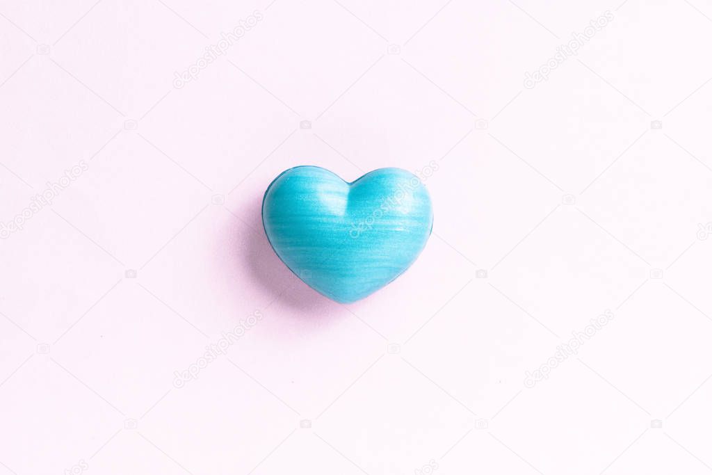 Blue heart shape over light color table. Top view of romantic symbol of valentines day for background use. Concept of love, romance, and passion.