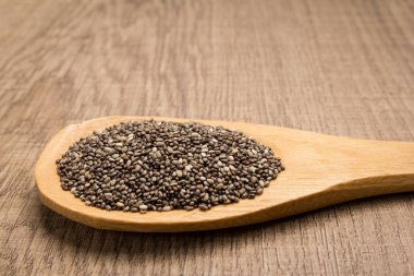 Salvia Hispanica, Chia Seed 'in bilimsel adıdır. Ayrıca Semente de Chia (Portekizce) olarak da bilinir. Tahta kaşıkta tahıllar. Kırsal.