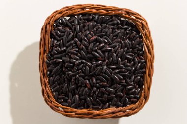 Oryza sativa, Black Rice tohumunun bilimsel adıdır. Ayrıca Arroz Negro (Portekizce) olarak da bilinir. Sepetteki tahılların üst görüntüsü. Kapat..