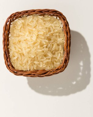 Oryza sativa, Çin pirinci tohumunun bilimsel adıdır. Ayrıca Arroz Agulha parboilizado (Portekizce) olarak da bilinir. Tahıllı hasır sepet. Üst manzara, sert ışık.