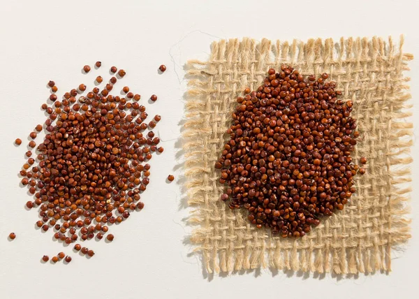 Chenopodiumキノアは紅キノアの種子の学名です 白いテーブルの上に広がる穀物の終わり — ストック写真