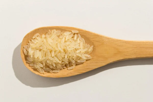 肉豆蔻是中国煮熟稻种的科学名称 也被称为Arroz Agulha Parboilizado 葡萄牙语 白色背景的木制勺子上有营养的谷物 — 图库照片