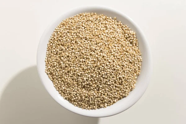 Chenopodiumキノアはゴールデンキノアの種子の学名です ボウルに穀物のトップビュー — ストック写真