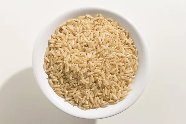 全麦稻种的学名是全麦稻种 也被称为长谷米和Arroz Agulha Integral 葡萄牙语 一碗谷粒的头像 白人背景 — 图库照片