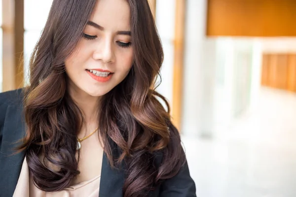 Güzel Asya iş kadını mavi ofis arka plan üzerinde.