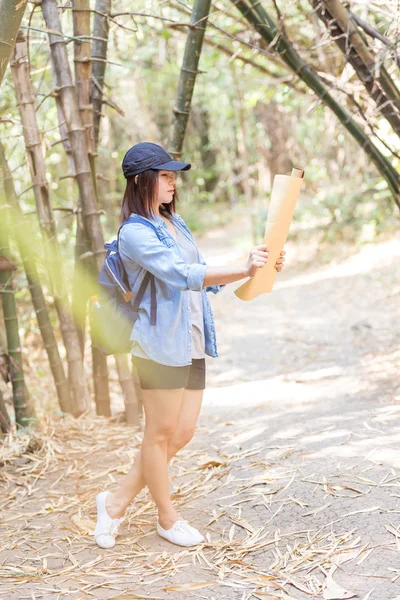 Woman with backpack holding a map in the countryside — Stock Photo, Image