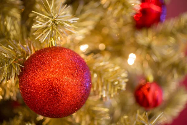 Palla di Natale rosso appeso all'albero di Natale d'oro e astratto — Foto Stock