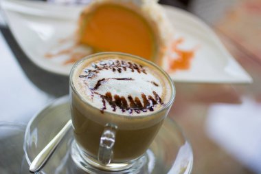 Masanın üstündeki çim bardakta Latte kahvesi manzarası..