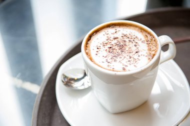 Masa örtüleri üzerinde kapuçino kahvesi.