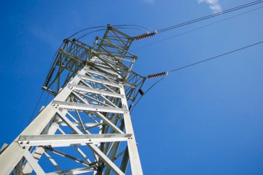 Mavi gökyüzü arka planında yüksek voltaj direği.