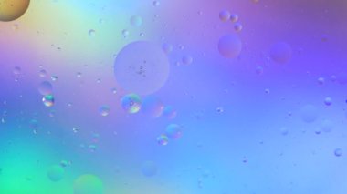 Sıvıdaki yağ kabarcıklarının üst görüntüsü. Yağ yüzeyi çok renkli arka plan. Renkli kabarcıklardan oluşan fantastik bir yapı. Suda yüzen yağ damlasının renkli sanatsal görüntüsü