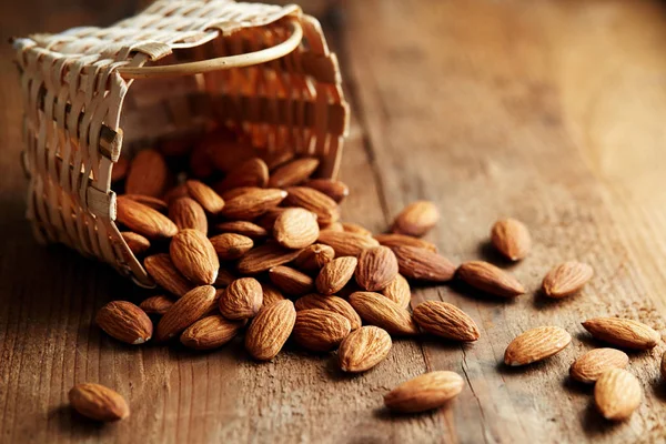 Almonds falling out of basket — Stock Photo, Image