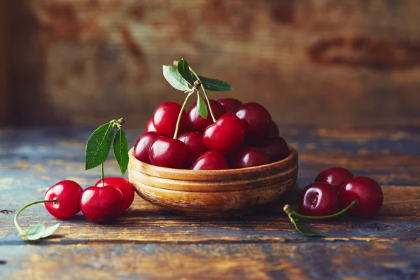 Cherries in a bowl on a wooden table — Stock Photo, Image
