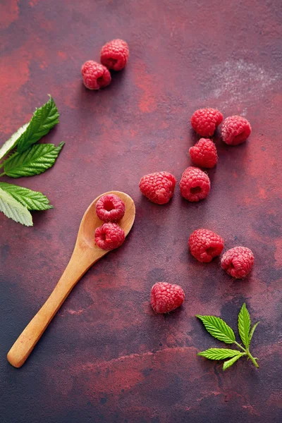 Raspberries with leaves and spoon — Stock Photo, Image