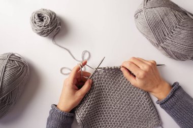 Kadın el ile beyaz arka planda gri yün örgü Üstten Görünüm