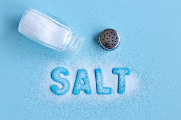 Nahaufnahme Von Verschüttetem Salz Und Offenem Salzstreuer Mit Blauen Buchstaben — Stockfoto