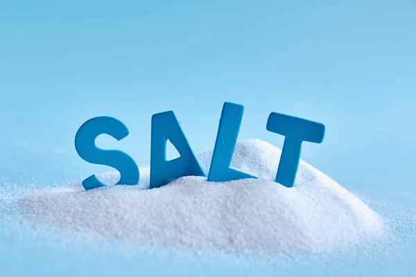 Närbild Foto Spilled Salt Och Blå Brev Stavning Ordet Salt — Stockfoto
