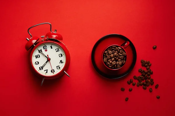 Granos Café Una Taza Con Despertador Retro Sobre Fondo Rojo — Foto de Stock