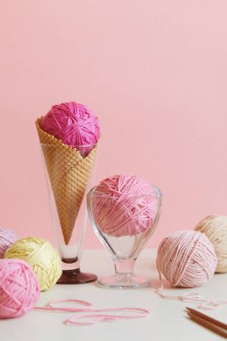 Pastel renkli iplik yumağı tatlı kasesinde ve waffle külahında. 