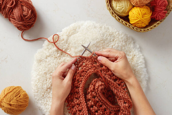 Женщина руки вязание шарф с иголками и Яр
