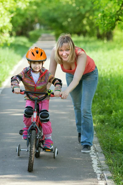 A mother is teaching small daughter to ride — Stock Photo, Image