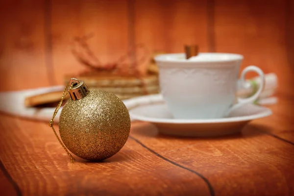 Cup of hot beverage with ornament ball — Stock Photo, Image