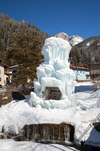 Ice fountain on river in Italian mountain village