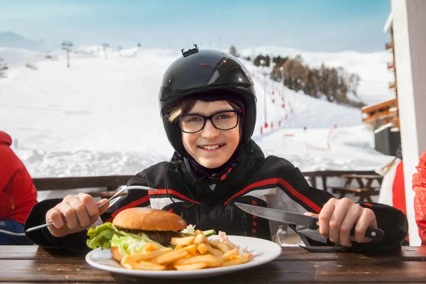 屋外のカフェで昼食をとる若いスキーヤーは — ストック写真