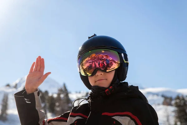 阳光明媚的时候 一个戴着滑雪头盔的男孩在山上的度假胜地 — 图库照片