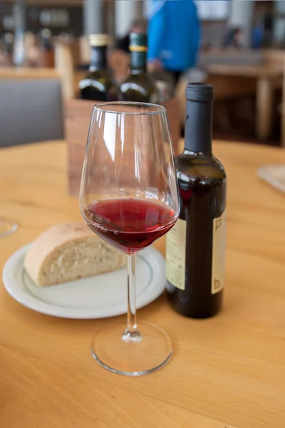 コーヒーテーブルの上にある赤ワインのグラスとボトルは — ストック写真