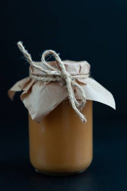 Koyu arkaplanda tuzlu karamel kavanozu