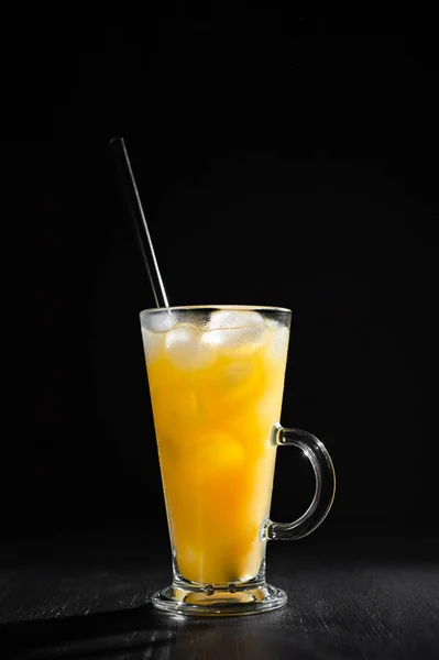 Glass of fresh orange juice with ice on a black background with a place for inscription — 스톡 사진