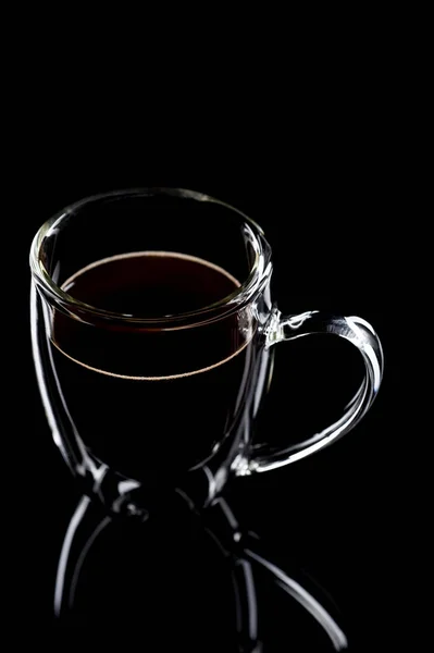 Xícara com café preto fica em vidro preto — Fotografia de Stock