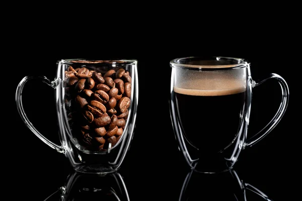 Composition of two cups with coffee on a black background. left side cup with coffee bean side view, right side cup with finished coffee side view. Black background — Stock Photo, Image