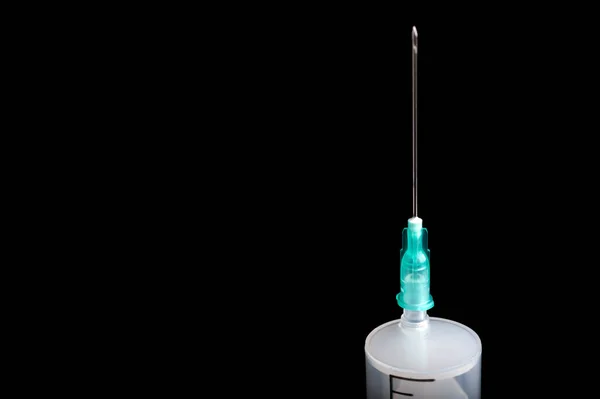 Jeringa médica de plástico vacía con una aguja sobre un fondo negro, espacio para copiar — Foto de Stock