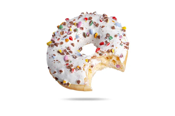 Een verse donut in wit glazuur wordt bestrooid met veelkleurige dragees met een chock binnenin. isoleren op witte achtergrond — Stockfoto